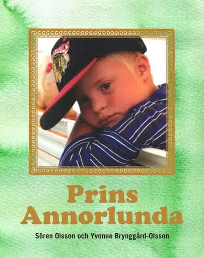 Bokens framsida med en ljusgrön akvarelliknande bakgrund. En inramad porträttbild på Ludvig som liten. Han har en svart keps med röd skärm på sig och en blå-vitrandig tröja. Under bilden står titeln Prins annorlunda i ljusbrun text.