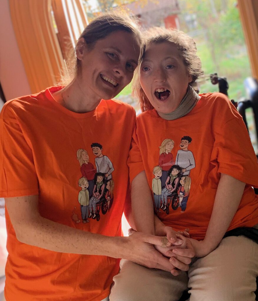 Anna och Agnes bär orangea t-shirts med karaktärerna i böckerna om Funkisfamiljen.