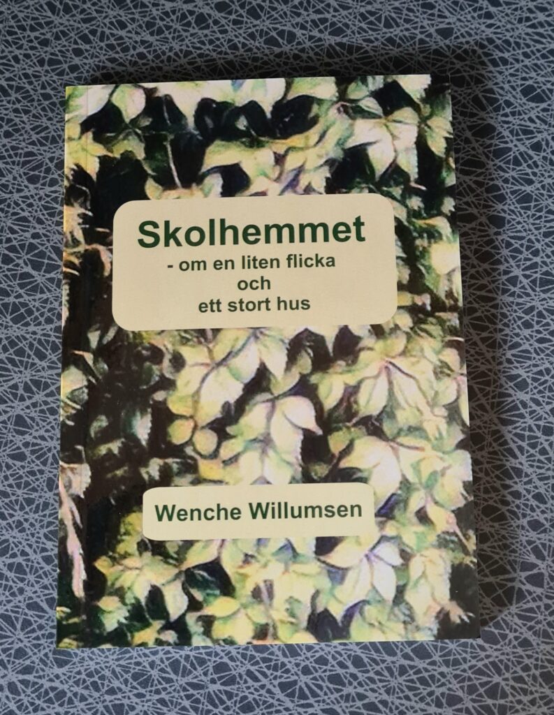Bokomslag: "Skolhemmet - om en liten flicka och ett stort hus" syns i grön text ovanpå ljusgröna löv som täcker hela omslaget i övrigt.
