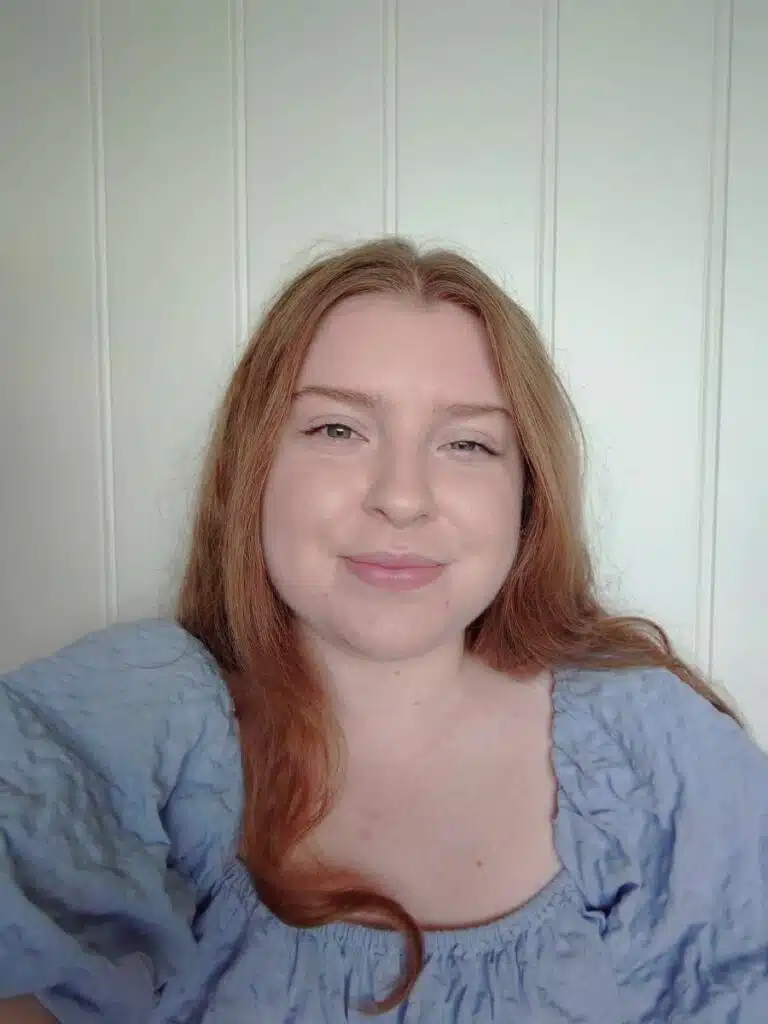 Hanna Kristiansson. Hon har långt rödbrunt hår och ler. Hon är klädd i en ljusblå u-ringad överdel.