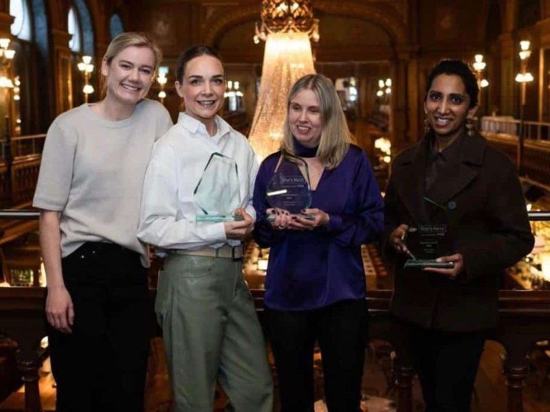 Pristagare She´s Next Stipendiet 2023. Fyra kvinnor står bredvid varandra och håller i var sin graverad glaskreation. Anna står i mitten. Samtliga ler mot kameran och befinner sig i en elegant stor lokal med kristallkrona och guld som syns i bakgrunden.